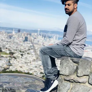 a man sitting on a wall overlooking a city