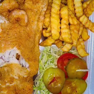 a fish and chips meal in a styrofoam container