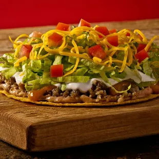 a taco topped with lettuce and cheese