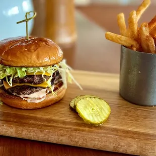 a hamburger and french fries on a cutting board