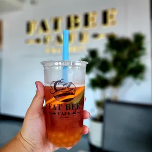 a hand holding a cup of iced tea