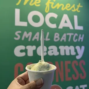 a hand holding a cup of ice cream