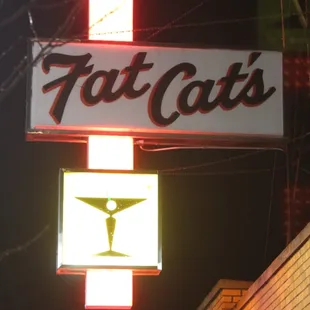 a neon sign for fat cats