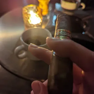 a hand holding a cigar