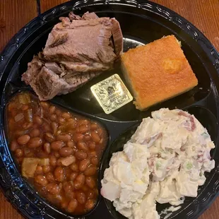 Brisket platter with potato salad baked beans and corn bread