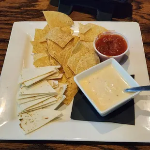 Queso served with salsa, chips and sliced flour tortilla