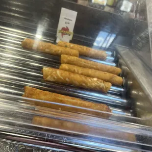 a row of hotdogs on a conveyor belt