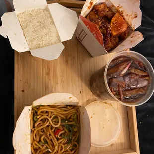 a plate of noodles, a bowl of rice, and a drink on a tray
