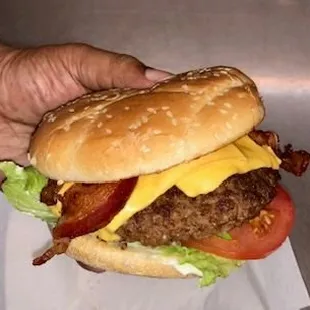 a hand holding a hamburger