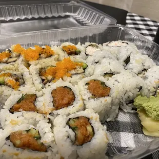 a plastic container of sushi