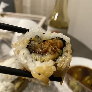 a close up of a sushi with chopsticks