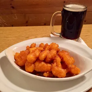 a bowl of tater tots and a mug of beer