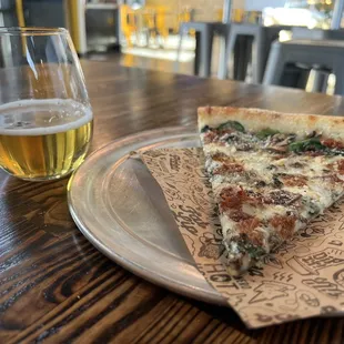 White Pizza Slice that has Bechamel, spinach, mushrooms and bacon.