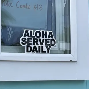 a sign in a window saying aloh served daily