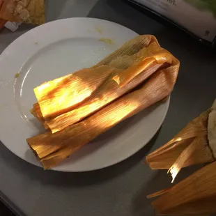a plate of tamales and a bag of chips