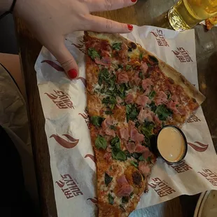 Canadian bacon &amp; spinach slice (hand for scale)