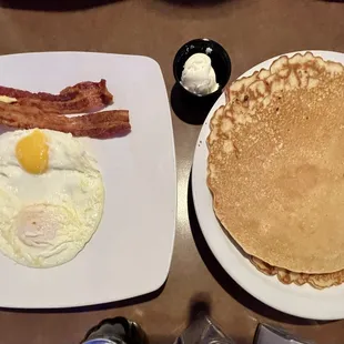 Griddle breakfast with eggs over easy, pancakes &amp; bacon.