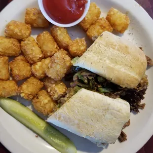 Cheesesteak sandwich on hoagie with tater tots