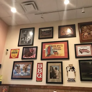 a wall full of framed pictures
