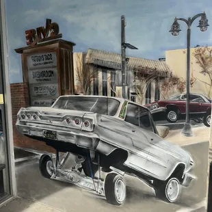 a painting of a car on the side of a building