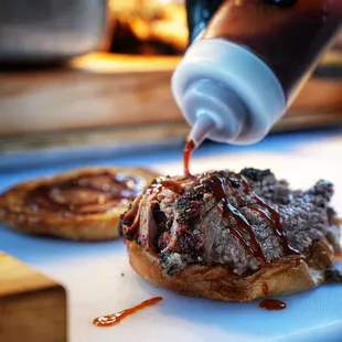 Prime Brisket sandwich being sauced up!