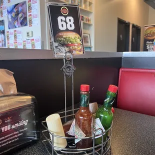 a table with hot sauces and condiments