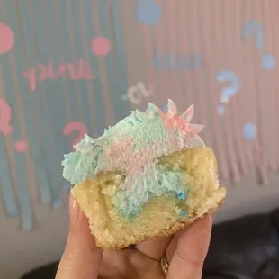 a hand holding a piece of cake