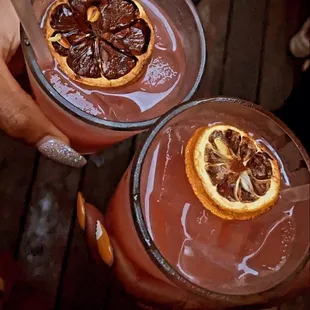 two glasses of chocolate pudding with orange slices