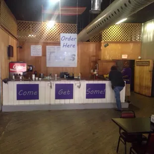a man standing at a counter in a restaurant