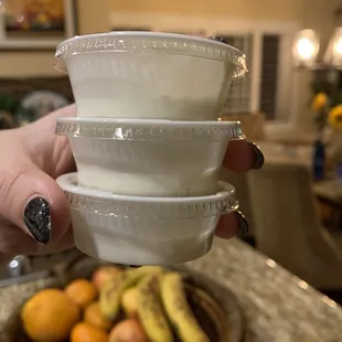 a person holding three bowls of fruit