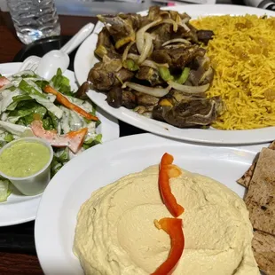 Lamb. Saffron rice w East African raisins, salad, pita and hummus.  Somalian soft drink can and bottled water