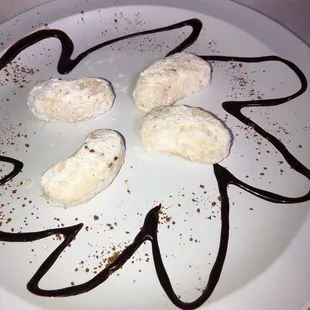 a white plate with four pieces of doughnuts on it