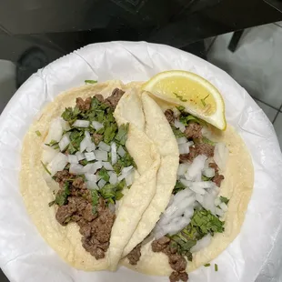 two tacos on a paper plate