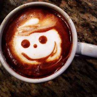 a cup of coffee with a smiley face drawn on it