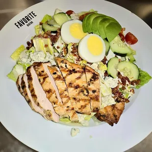 A vibrant Cobb Salad topped with sliced grilled chicken