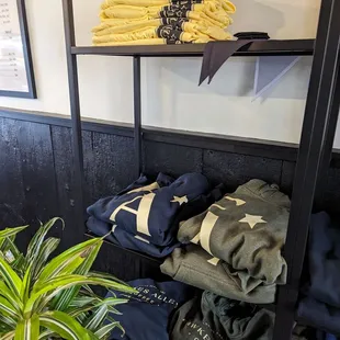 a shelf of clothing and a potted plant