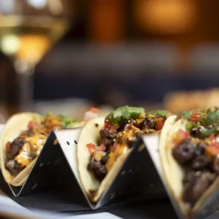 a plate of tacos and a glass of wine