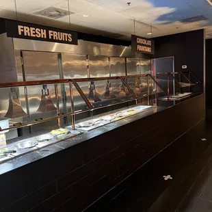 a restaurant counter with a large display of fresh fruits