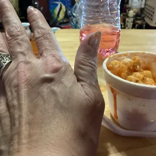 Small side of Mac and cheese and my hand for comparison. The red is hot sauce(not included, I added that.