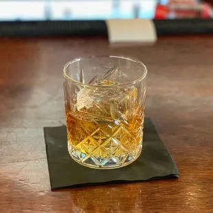 a glass of whiskey on a napkin
