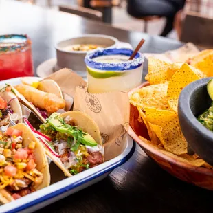 a plate of tacos and a bowl of chips