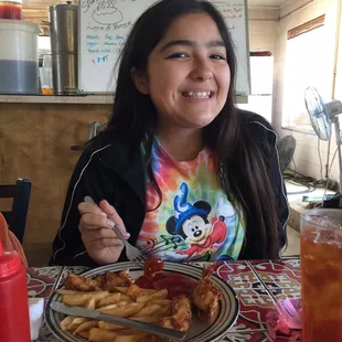 Our picky eater enjoying her chicken strips and fries.