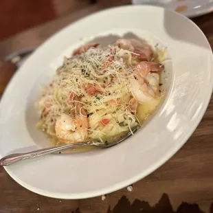 a plate of pasta with shrimp and cheese