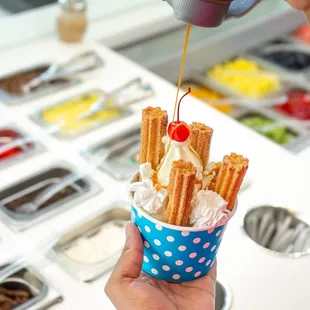a hand holding a cup of ice cream