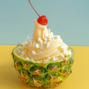 a pineapple topped with whipped cream and a cherry