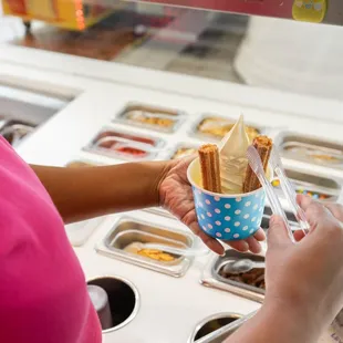 a woman holding a cup of ice cream