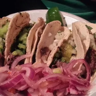 Lengua and cabeza tacos, pickled onion