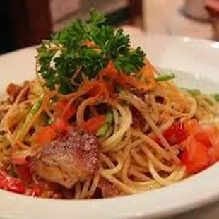 a plate of spaghetti with meat and vegetables