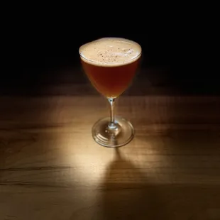 a glass of beer on a wooden table