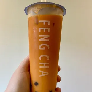 a hand holding a cup of iced tea